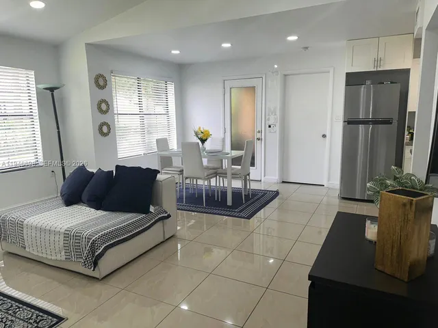 a living room with furniture a large window and a chandelier