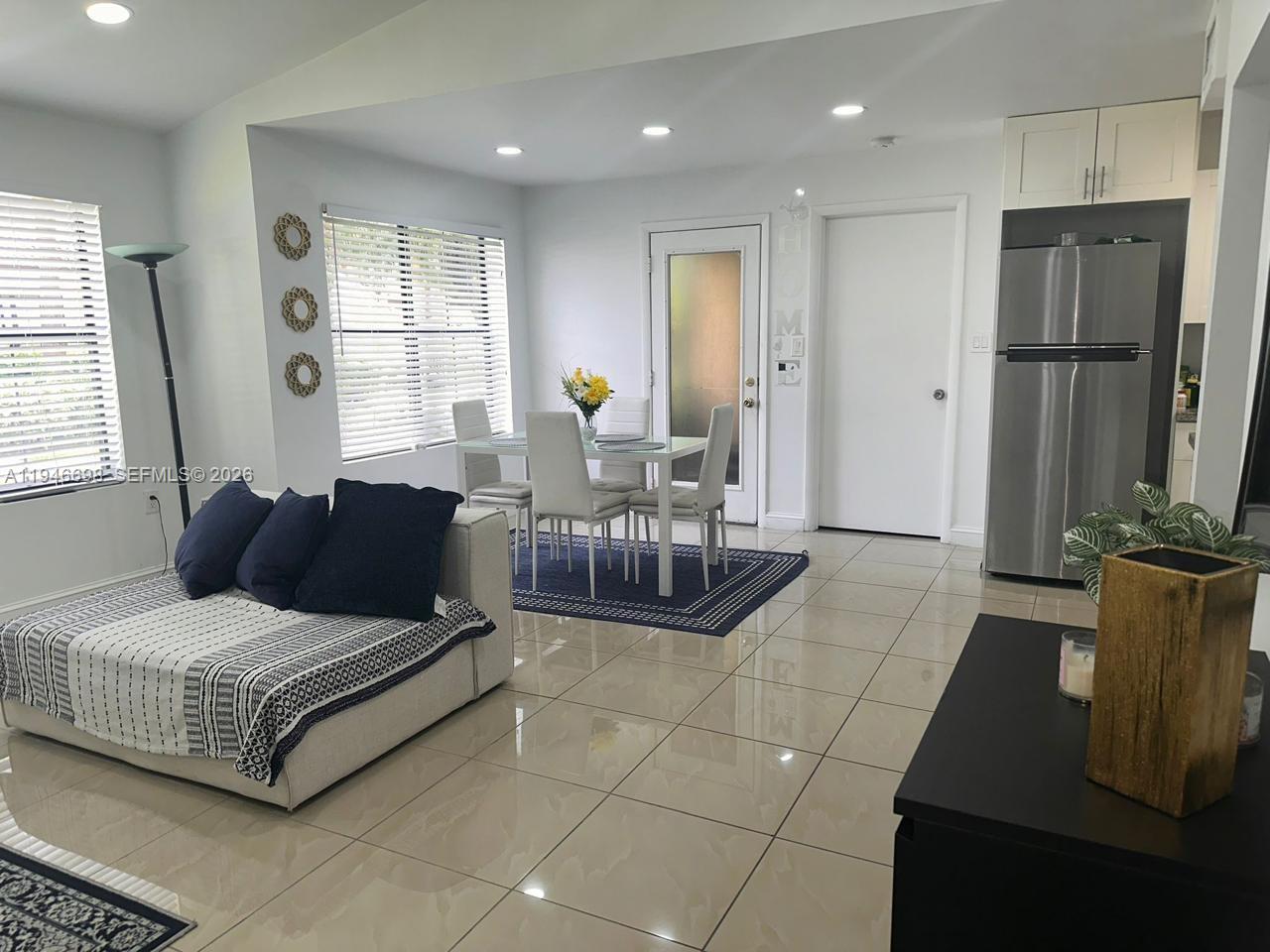 15560 Southwest 104th Terrace, Unit 6112 Miami, FL 33196 - Photo 3 of 12 a living room with furniture a large window and a chandelier