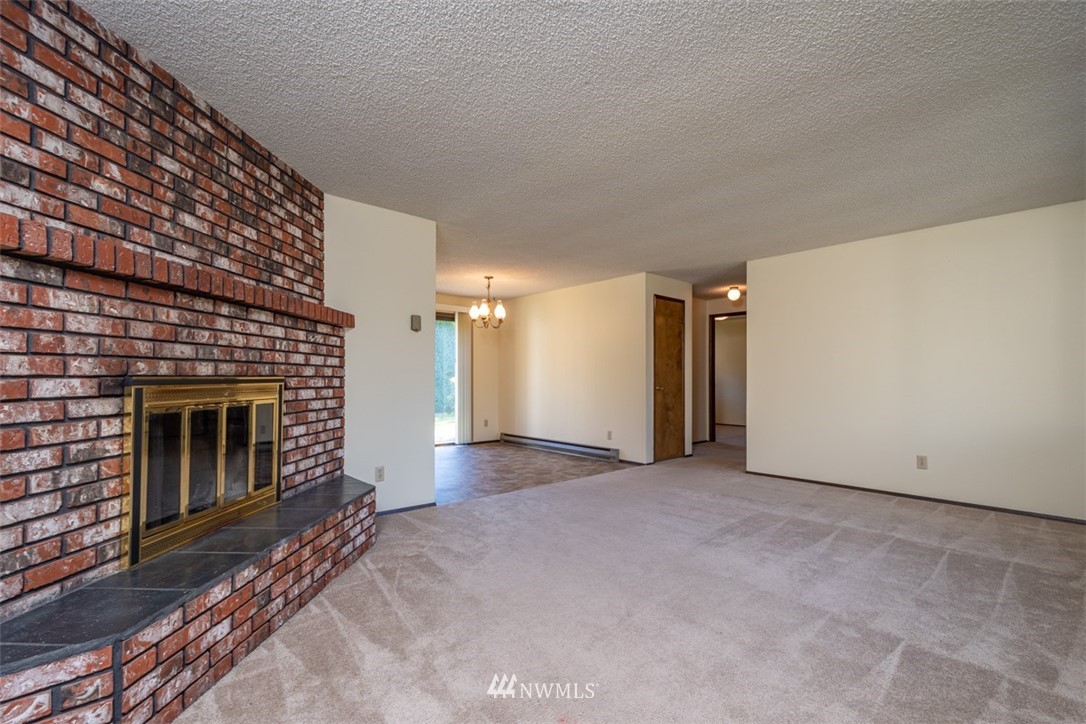 18630 Albany Street Southwest Rochester, WA 98579 - Photo 15 of 21 a view of empty room with wooden floor and fireplace