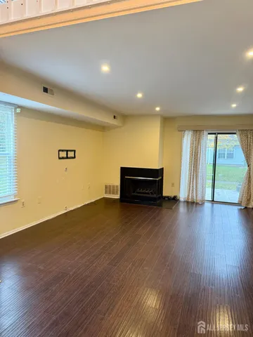 a view of room with wooden floor and windows