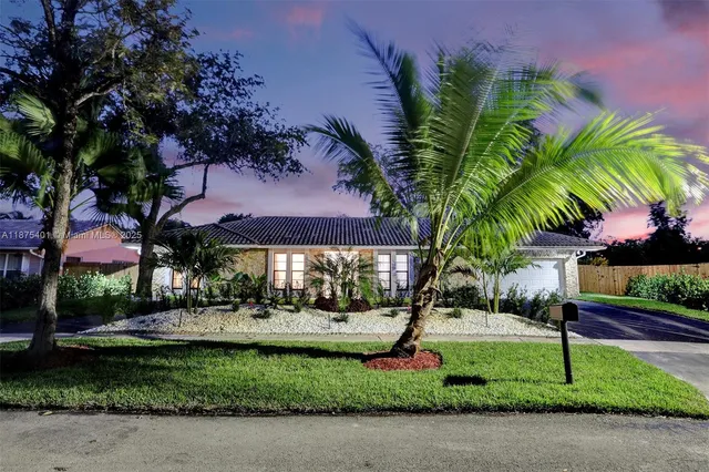 an aerial view of residential houses with outdoor space and trees