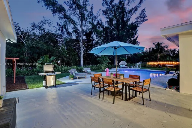 a kitchen with stainless steel appliances granite countertop white cabinets a sink a stove a refrigerator and cabinets