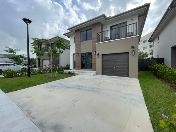 a front view of a house with a yard and garage