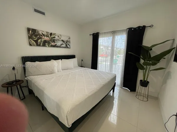 a bedroom with a large bed and a flat tv screen