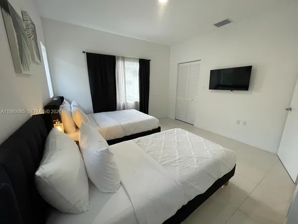 a bedroom with two beds and painting on the wall
