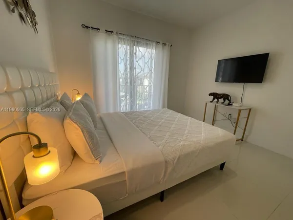 a bedroom with a bed and a flat screen tv