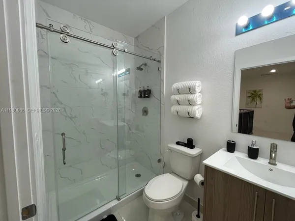 a bathroom with a sink a toilet and shower