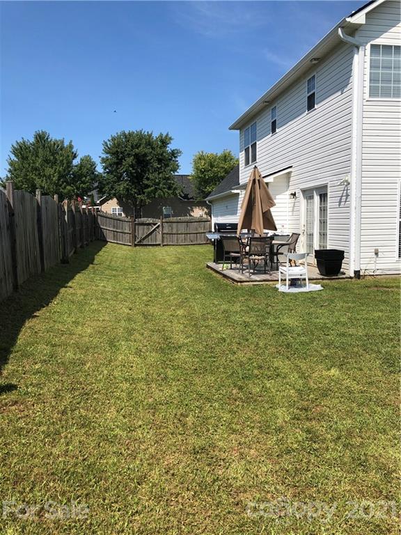 138 Yadkin Road, Unit 129 Fletcher, NC 28732 - Photo 22 of 37 a view of a backyard with table and chairs a barbeque and wooden fence