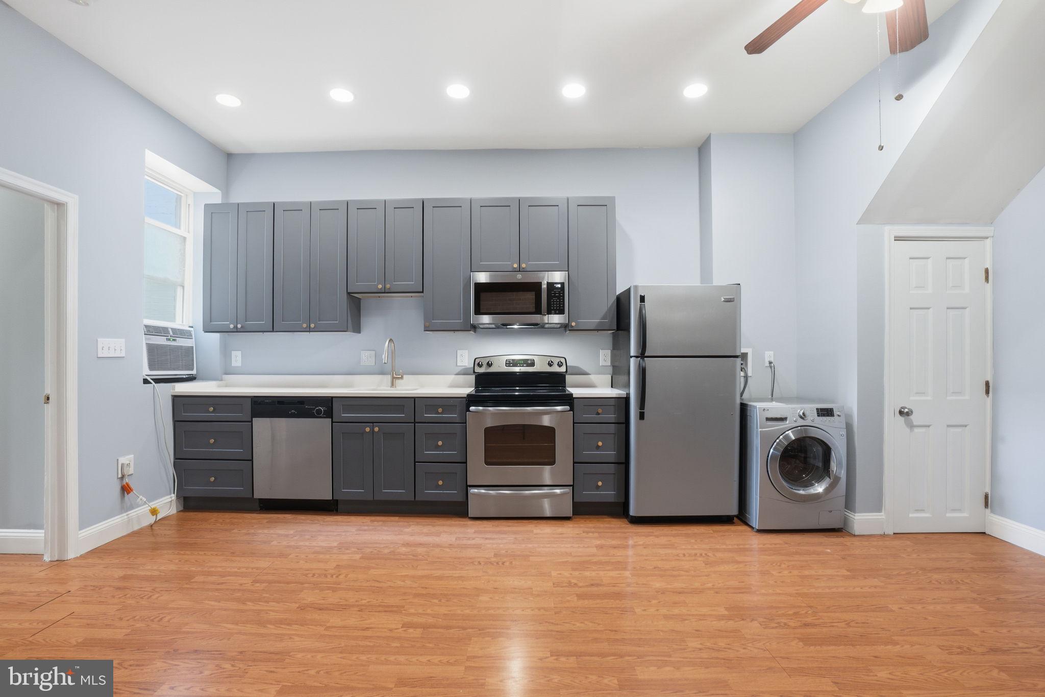 1440 Fairmont Street Northwest, Unit 3 Washington, DC 20009 - Photo 2 of 21 a kitchen with granite countertop a refrigerator and a stove top oven