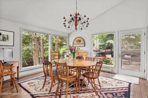 a view of a dining room with furniture a chandelier and wooden floor