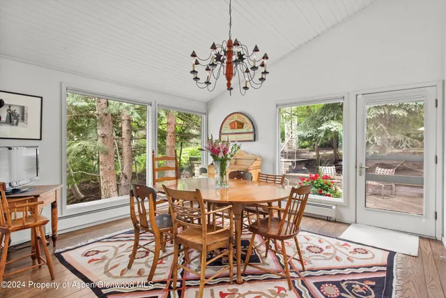 a view of a dining room with furniture a chandelier and wooden floor