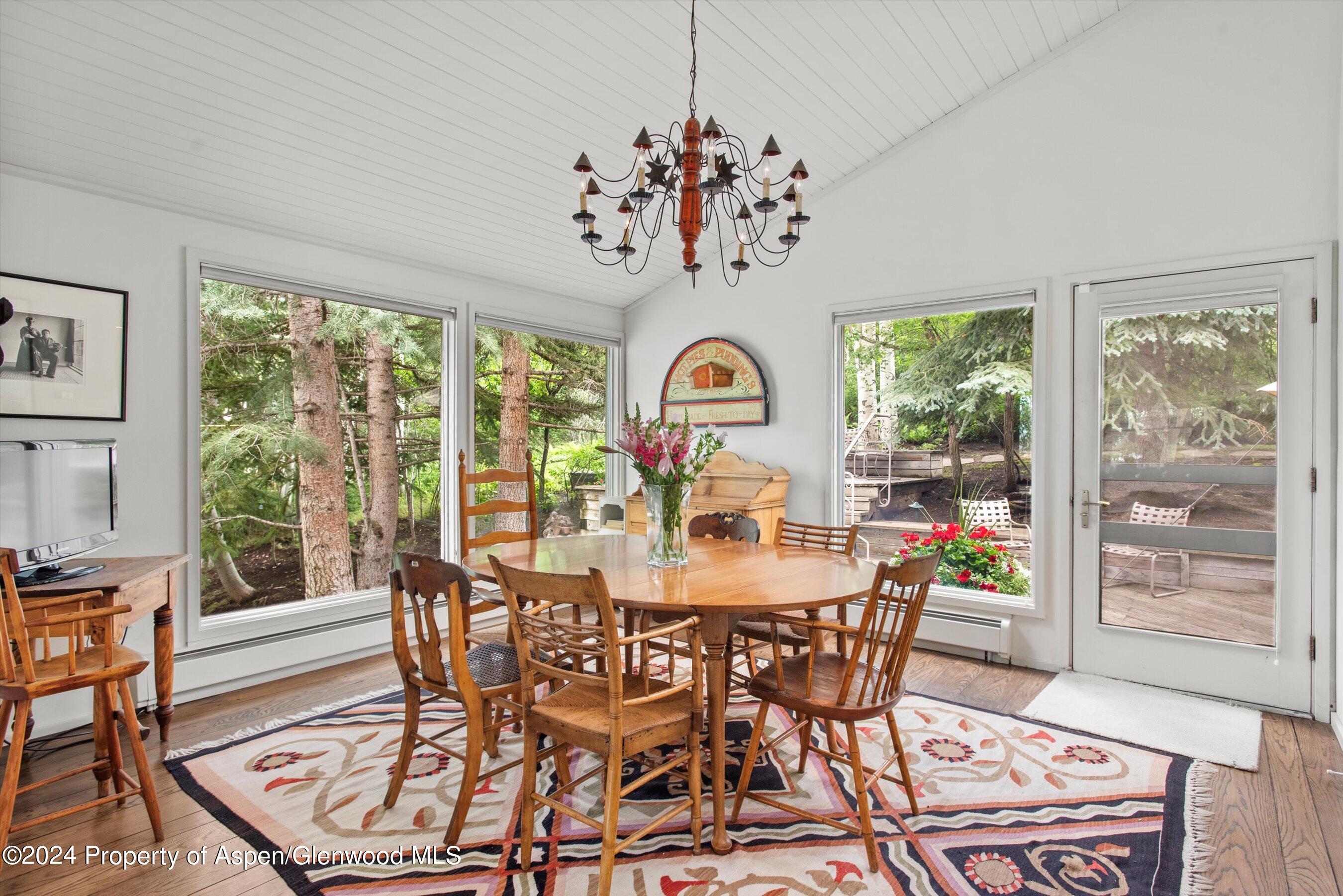 209 Larkspur Lane Aspen, CO 81611 - Photo 20 of 45 a view of a dining room with furniture a chandelier and wooden floor