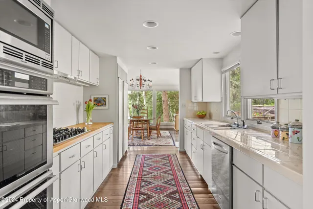 a large kitchen with stainless steel appliances granite countertop a lot of counter space and wooden floors