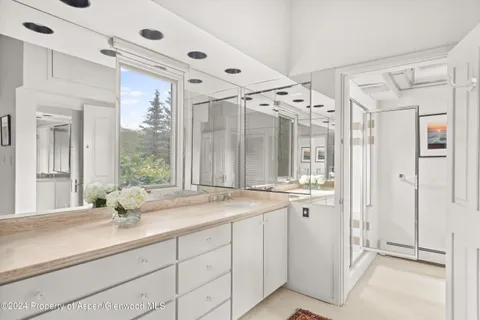 a bathroom with a shower sink vanity granite and mirror