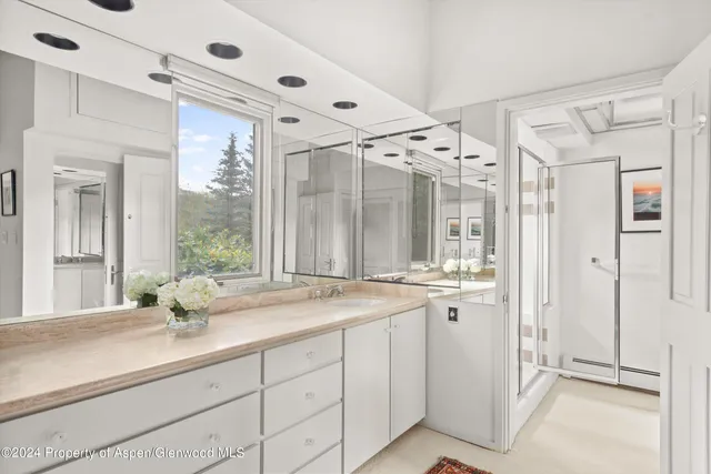 a bathroom with a shower sink vanity granite and mirror