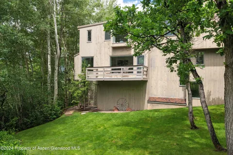 a view of a house with backyard and a garden