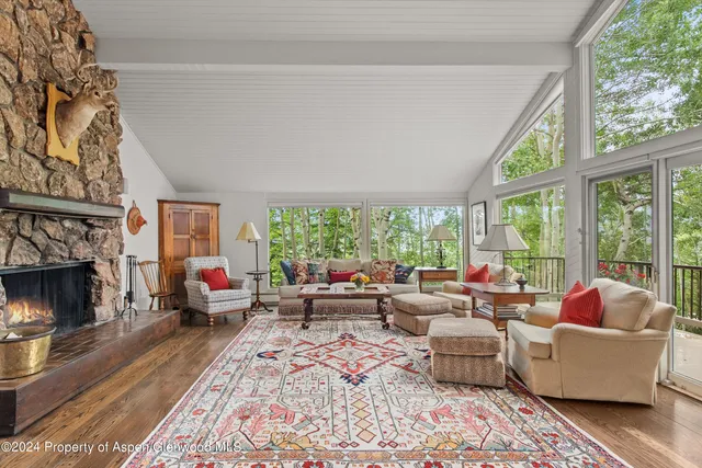 a living room with furniture large window and a fireplace