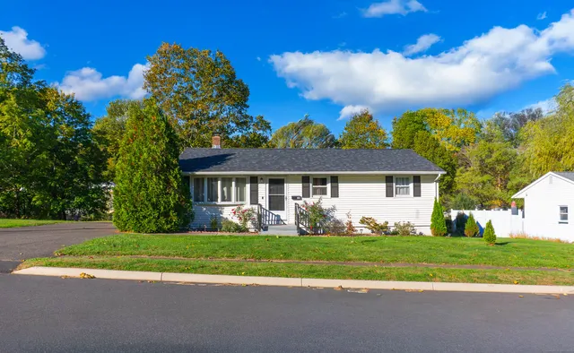 a front view of a house with a garden and yard