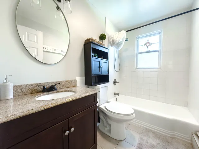 a bathroom with a toilet a sink and mirror