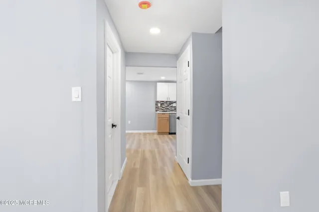 a view of a room with wooden floor and a bathroom