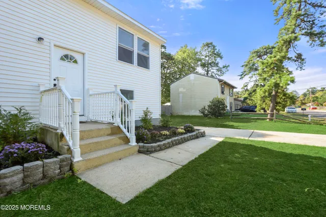 a view of a house with backyard and sitting area