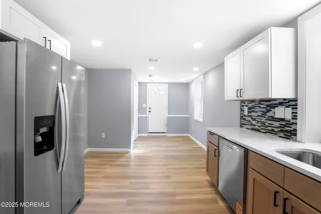 a kitchen with stainless steel appliances granite countertop a refrigerator and a sink