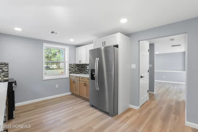 a kitchen with stainless steel appliances a refrigerator and wooden floor