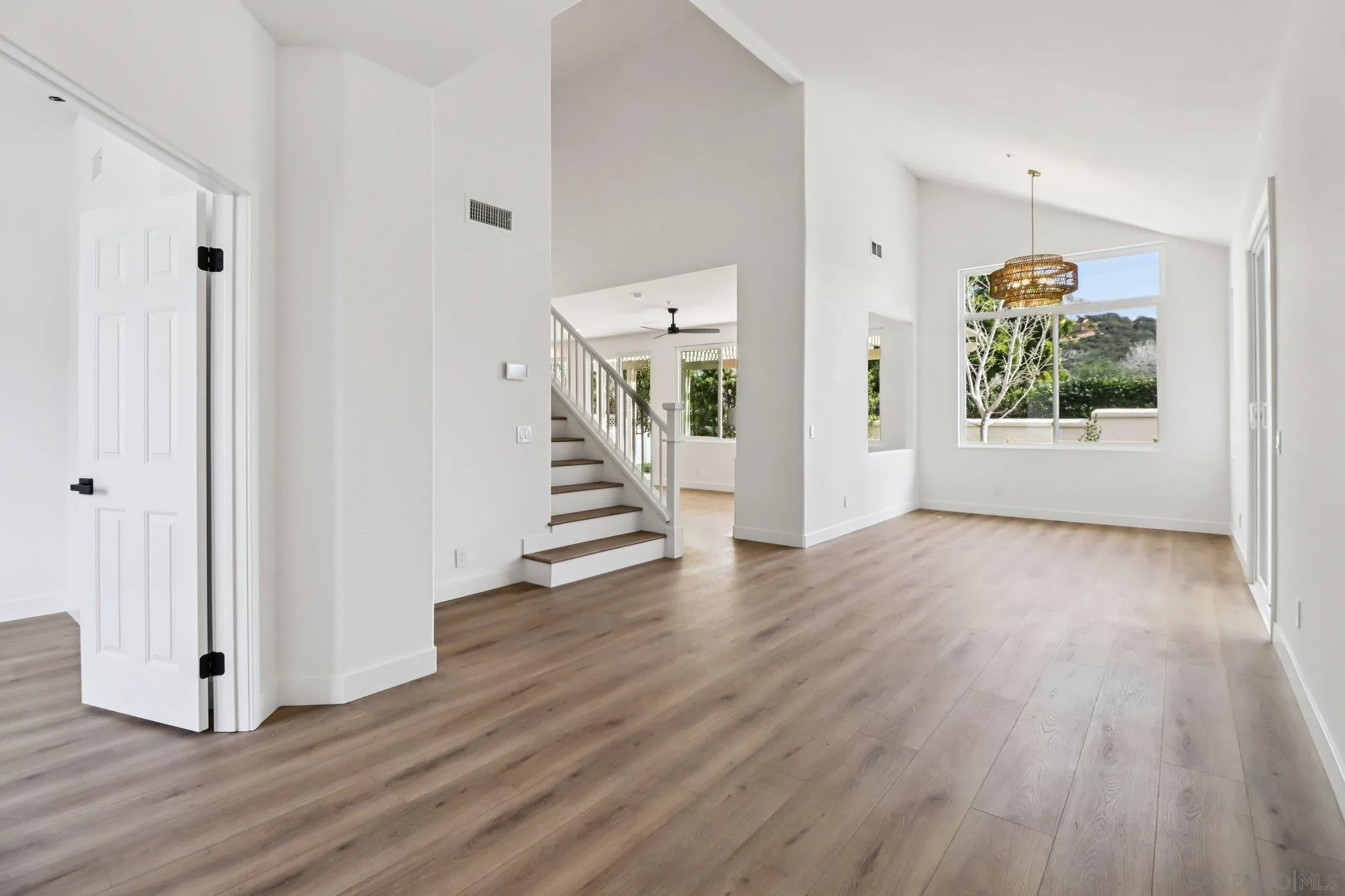 a view of a hallway with wooden floor and entryway
