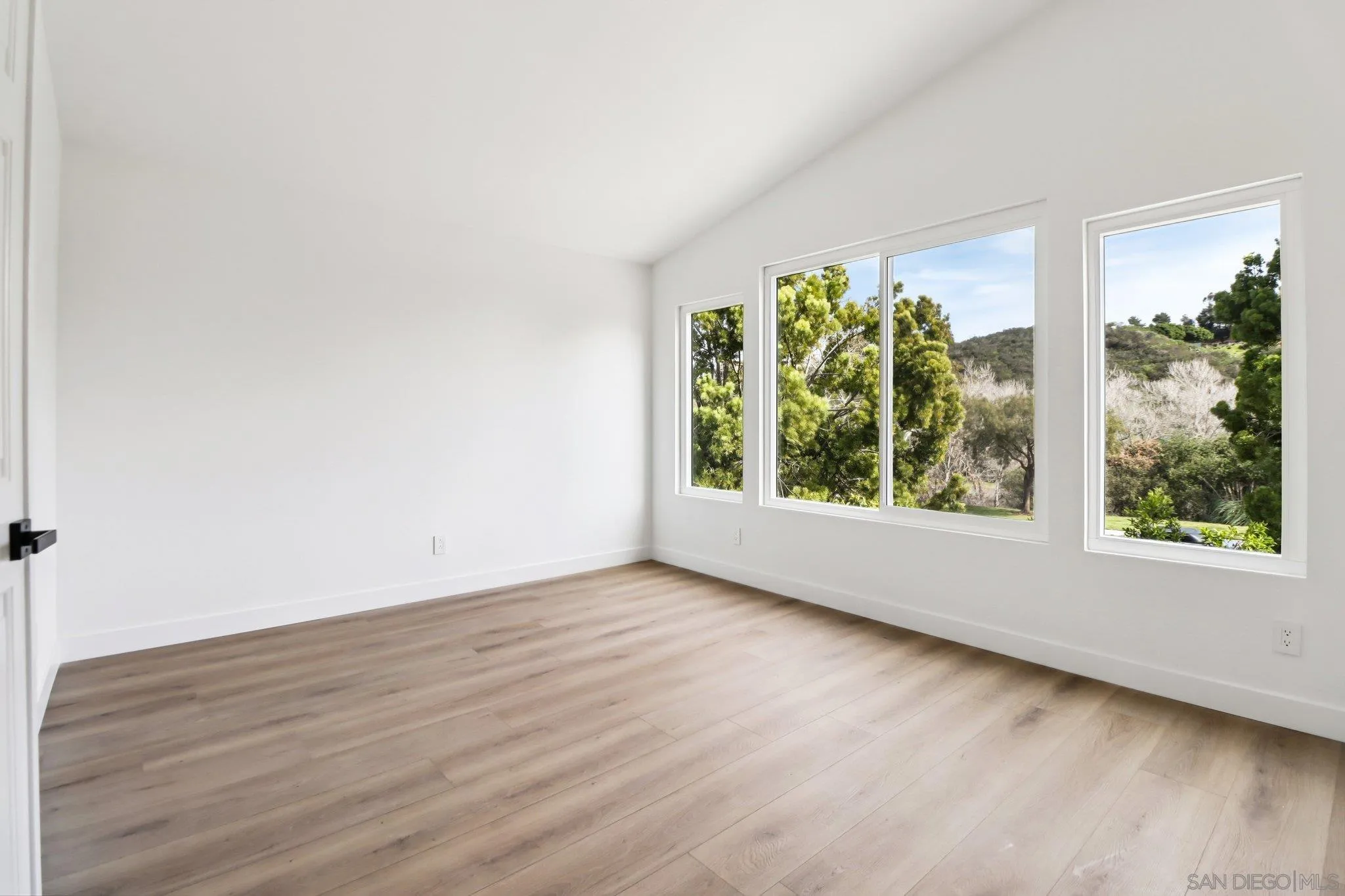 2082 Fairhope Loop Vista, CA 92081 - Photo 15 of 27 a view of an empty room with wooden floor and a window