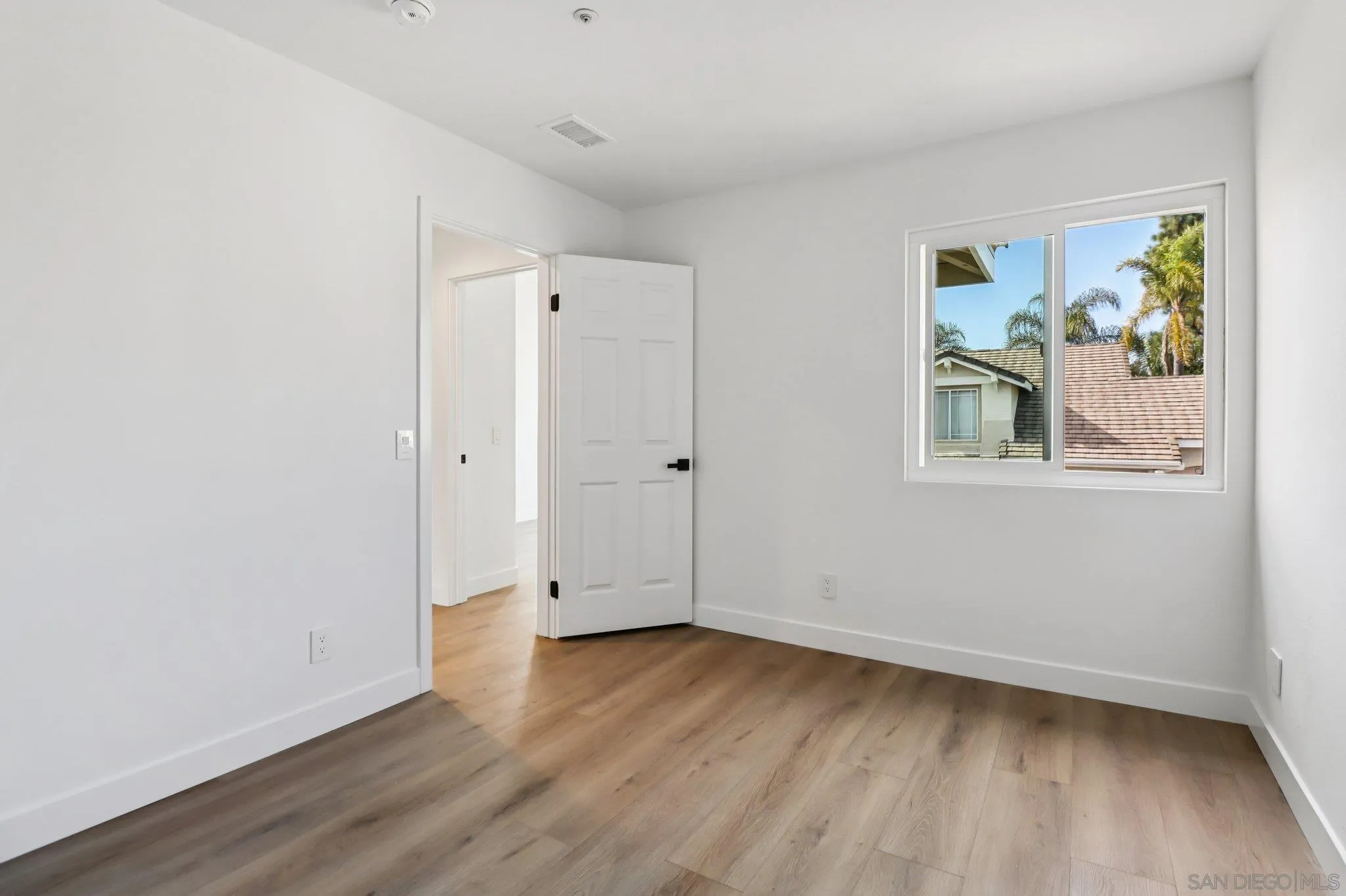 2082 Fairhope Loop Vista, CA 92081 - Photo 17 of 27 an empty room with wooden floor and window
