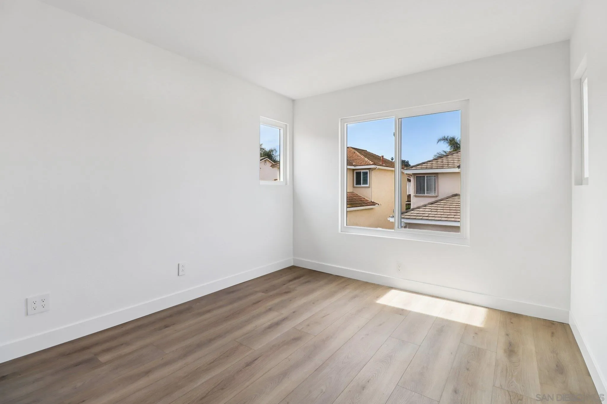 2082 Fairhope Loop Vista, CA 92081 - Photo 19 of 27 an empty room with wooden floor and windows