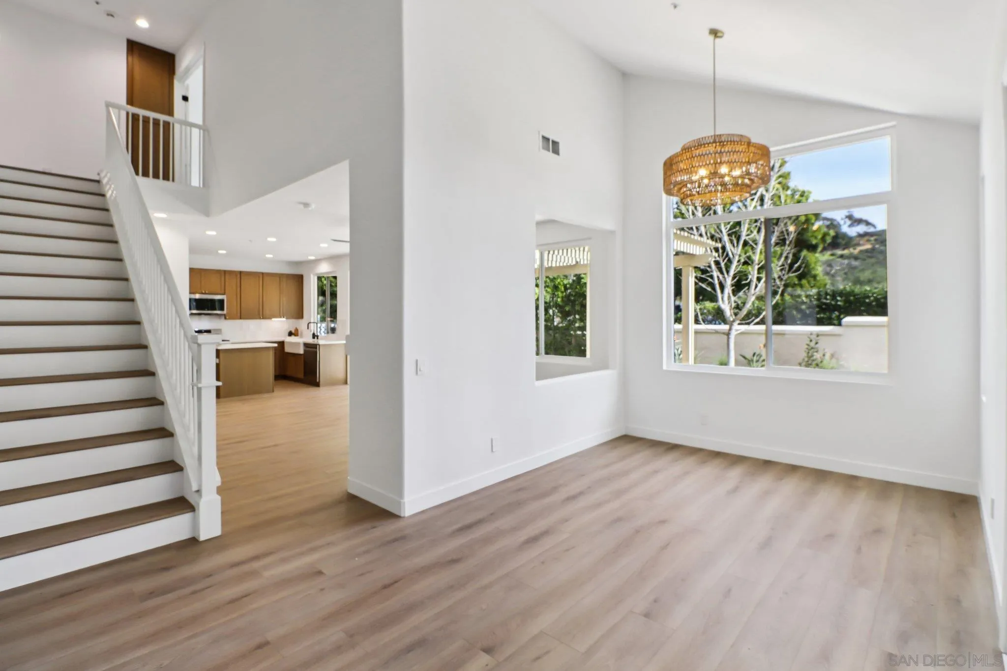 2082 Fairhope Loop Vista, CA 92081 - Photo 8 of 27 an empty room with wooden floor staircase and windows