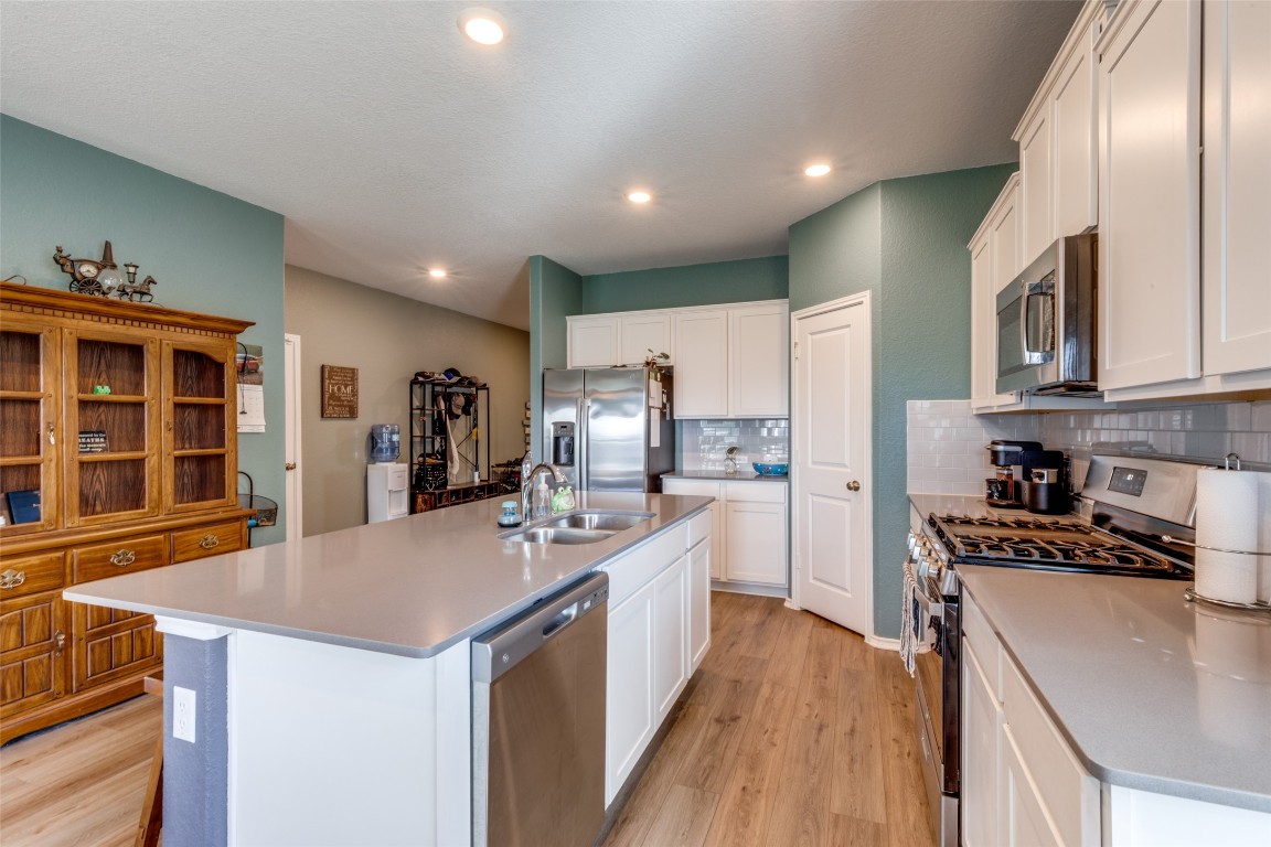 207 Otter Road Kyle, TX 78640 - Photo 11 of 26 a kitchen with stainless steel appliances granite countertop a sink a stove and a refrigerator