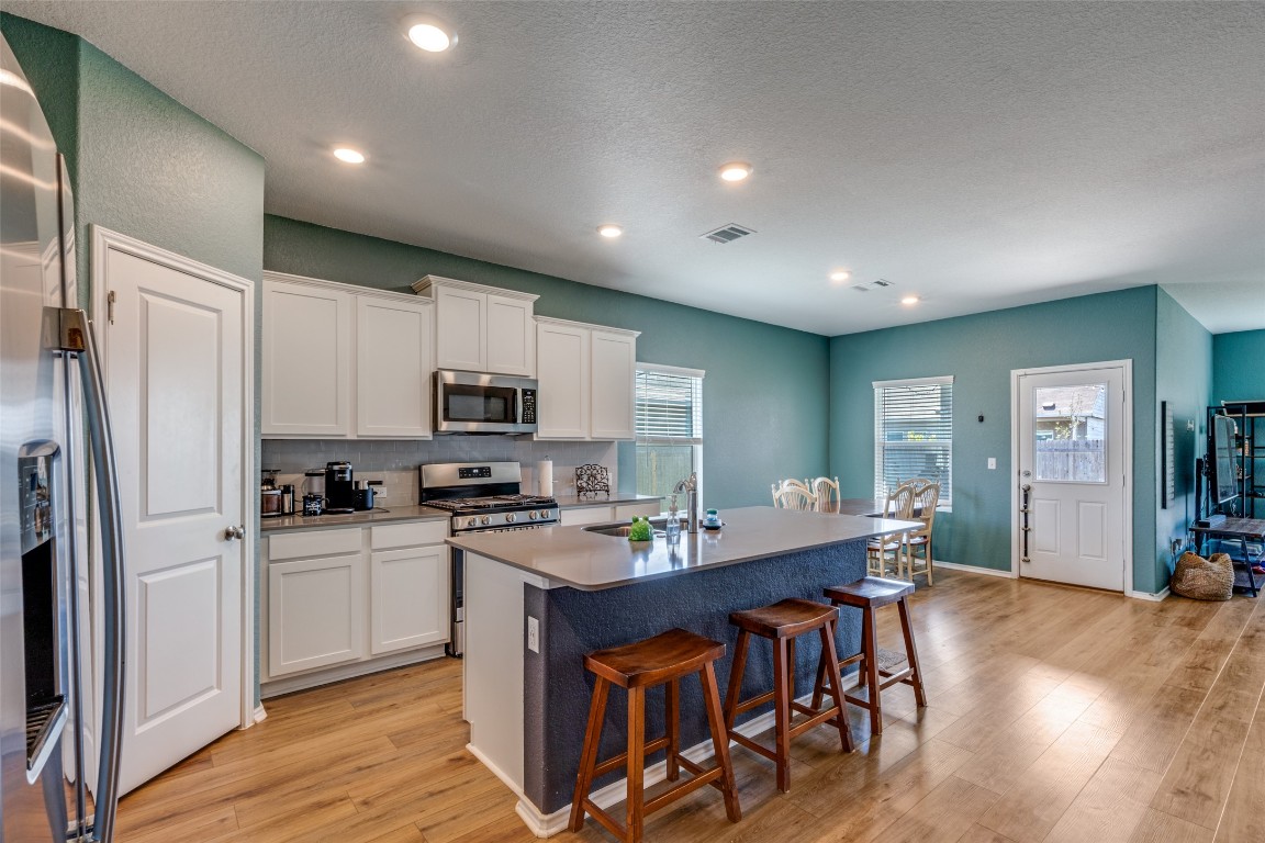 207 Otter Road Kyle, TX 78640 - Photo 8 of 26 a kitchen with kitchen island granite countertop a sink appliances and cabinets