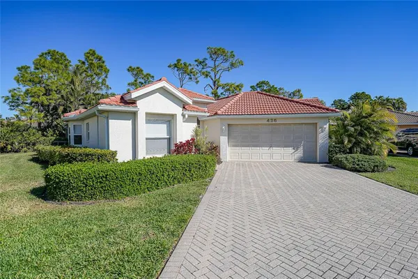 a front view of a house with a garden and yard