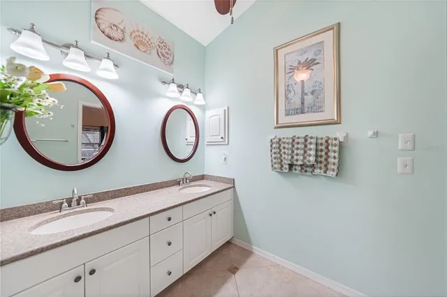 a bathroom with a granite countertop double vanity sink and a mirror