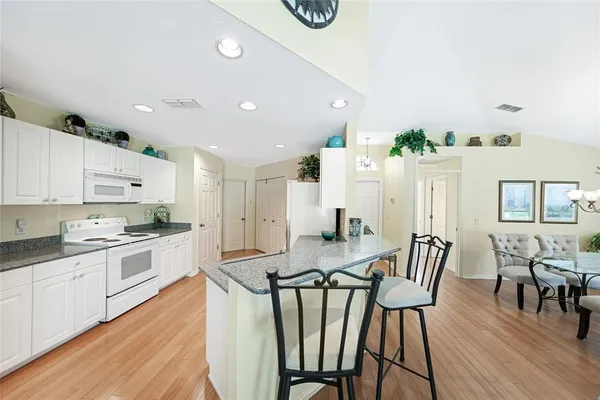 a kitchen with granite countertop white cabinets and stainless steel appliances