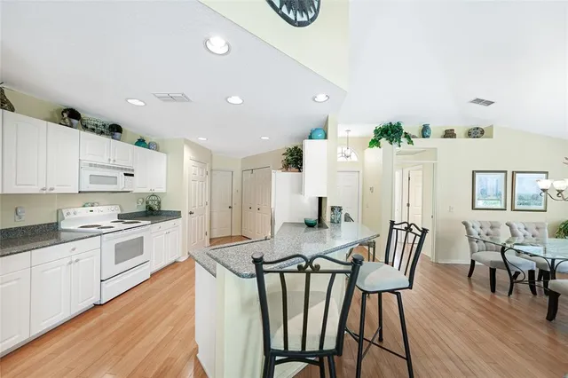a kitchen with granite countertop white cabinets and stainless steel appliances