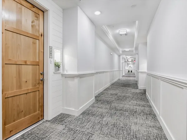 a view of a hallway with wooden floor and entryway