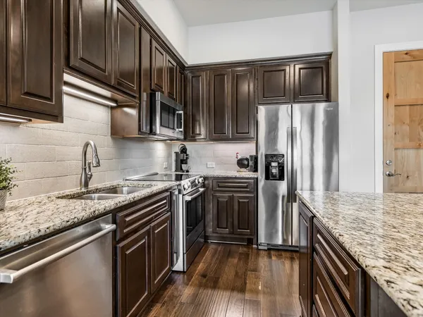 a kitchen with granite countertop stainless steel appliances and wooden cabinets