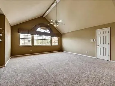 a view of an empty room with a chandelier fan