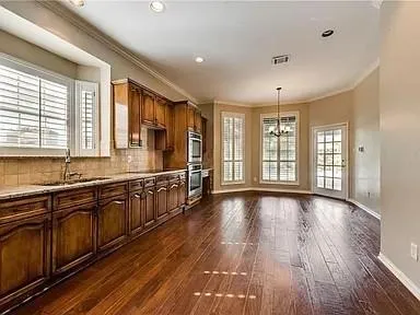 a large kitchen with stainless steel appliances granite countertop a large window a sink and cabinets