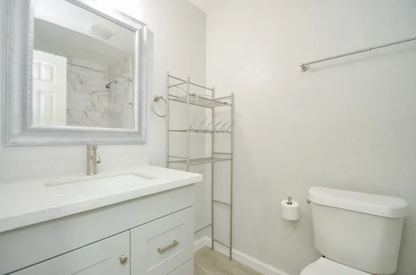 a bathroom with a sink a toilet and mirror