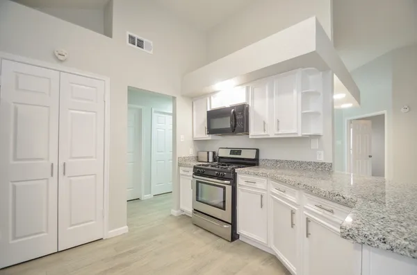 a kitchen with white cabinets stainless steel appliances and sink