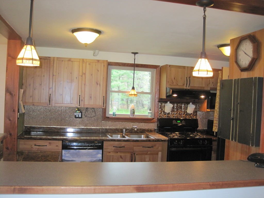15 Kimbrough Road Billerica, MA 01821 - Photo 3 of 15 a kitchen with kitchen island granite countertop a stove a sink and a microwave