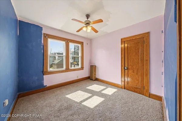 a view of a livingroom with a window and a ceiling fan