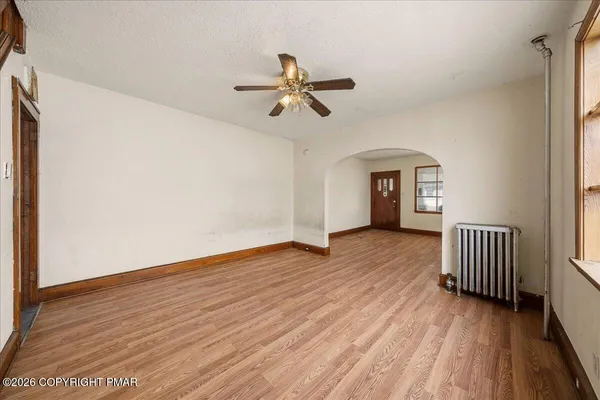 a view of empty room with wooden floor