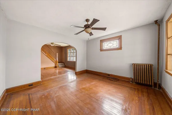 a view of a livingroom with wooden floor and a ceiling fan