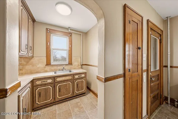 a utility room with stainless steel appliances granite countertop a sink a stove and a refrigerator
