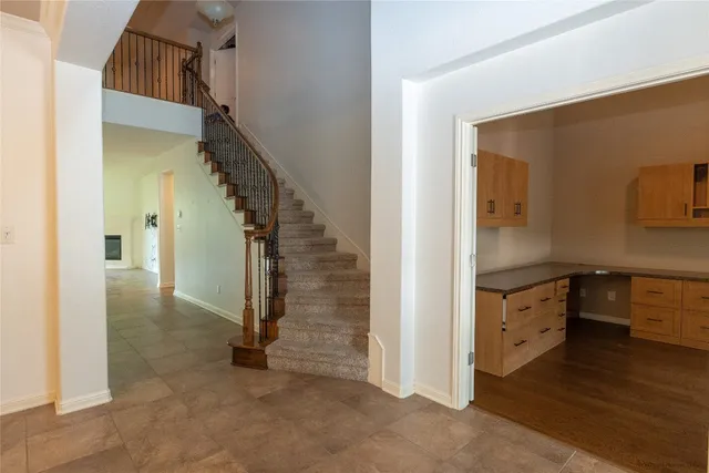 a view of hallway with stairs and wooden floor